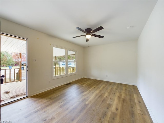 unfurnished room with visible vents, wood finished floors, baseboards, and ceiling fan