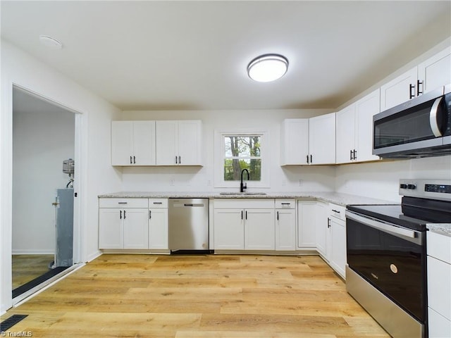 kitchen with a sink, stainless steel appliances, and white cabinets