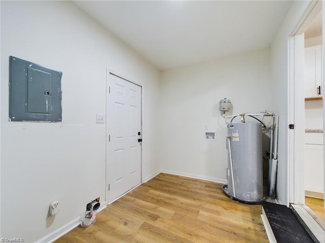 clothes washing area with light wood finished floors, baseboards, gas water heater, electric panel, and laundry area