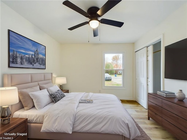 bedroom featuring a closet, light wood-style flooring, and a ceiling fan