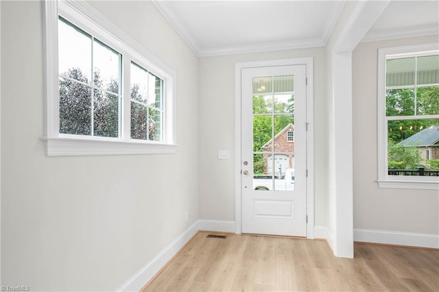 doorway featuring crown molding and light hardwood / wood-style floors