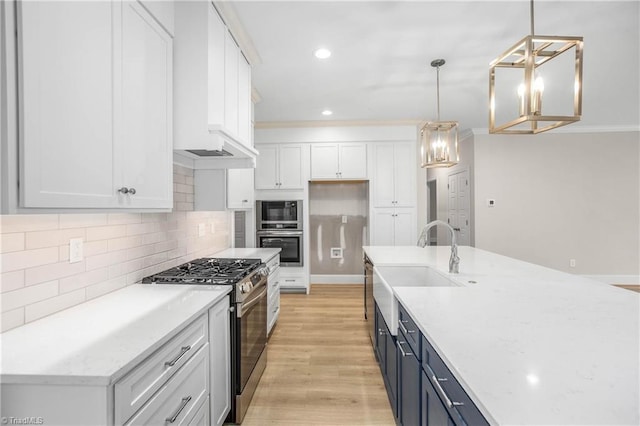 kitchen featuring gas range, decorative light fixtures, light stone counters, and white cabinets