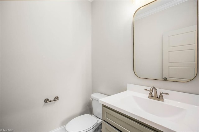 bathroom with vanity, ornamental molding, and toilet