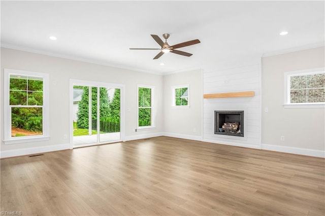 unfurnished living room featuring a wealth of natural light, a fireplace, and light hardwood / wood-style flooring