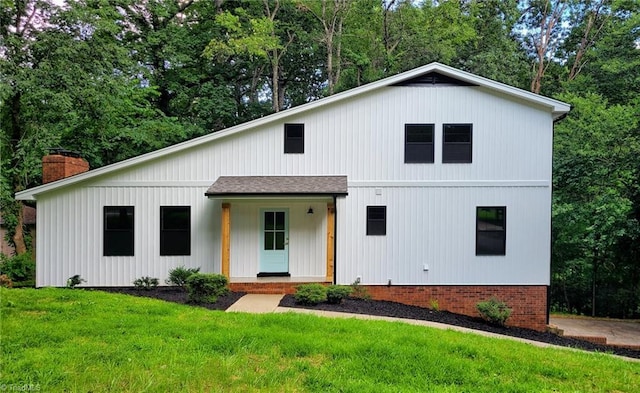 1628 Eagle Crest Dr, Pfafftown, NC 27040 - modern farmhouse featuring a front yard, a chimney, a shingled roof, and view of scattered trees