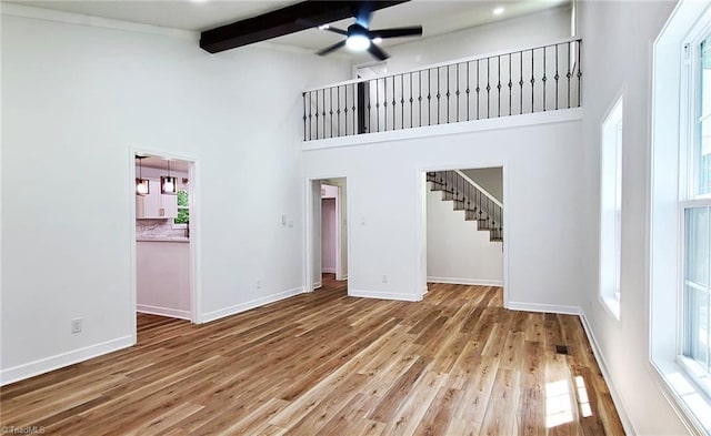 1628 Eagle Crest Dr, Pfafftown, NC 27040 - unfurnished living room featuring a ceiling fan, beam ceiling, a towering ceiling, wood finished floors, and stairs