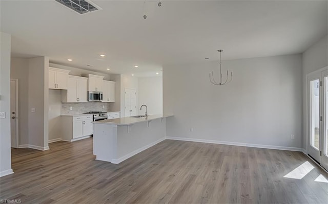 kitchen with appliances with stainless steel finishes, visible vents, a sink, and white cabinetry