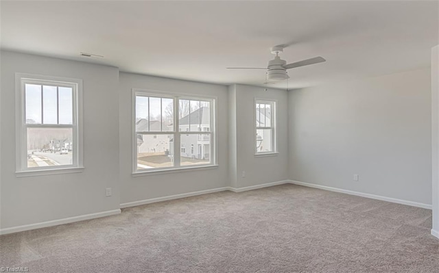 spare room featuring carpet, baseboards, and a ceiling fan