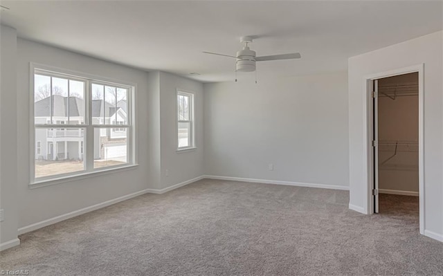 empty room with carpet, ceiling fan, and baseboards