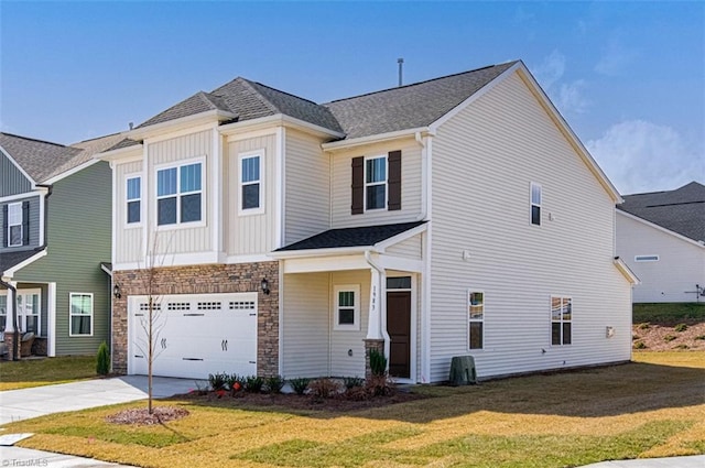 view of front of house with board and batten siding, a front yard, stone siding, and driveway