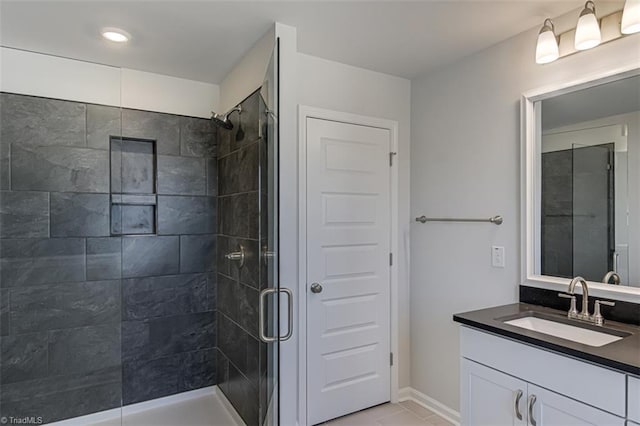 bathroom featuring a stall shower, baseboards, and vanity