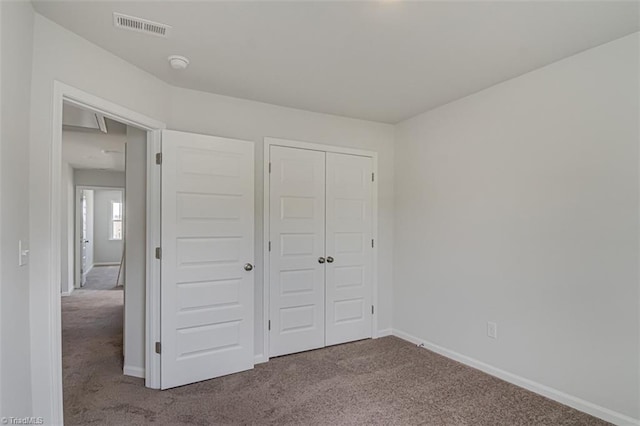 unfurnished bedroom featuring carpet, visible vents, and baseboards