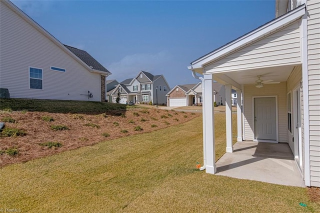 view of yard featuring a residential view and a ceiling fan