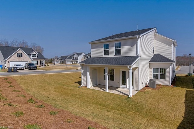 rear view of house featuring a residential view, a lawn, a patio, and central AC unit