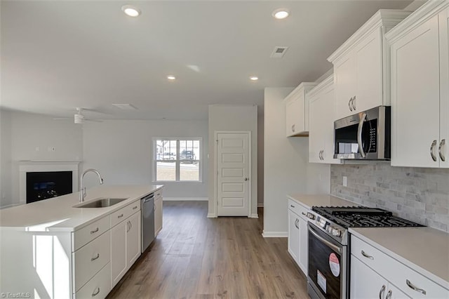 kitchen featuring a sink, visible vents, light countertops, appliances with stainless steel finishes, and decorative backsplash