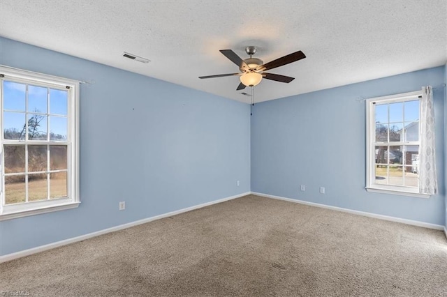 empty room featuring baseboards, a textured ceiling, visible vents, and carpet flooring