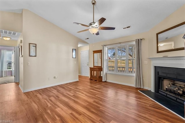 unfurnished living room featuring visible vents, baseboards, a fireplace with raised hearth, a ceiling fan, and light wood-type flooring