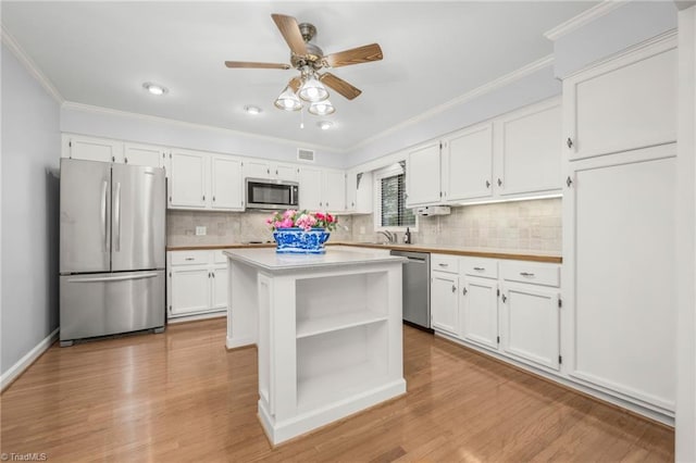 191 Fairway Dr, Advance, NC 27006 - kitchen with stainless steel appliances, white cabinets, crown molding, light countertops, and open shelves
