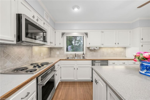 191 Fairway Dr, Advance, NC 27006 - kitchen featuring stainless steel appliances, a sink, light countertops, white cabinetry, and ornamental molding