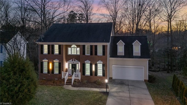 view of front of property with driveway, brick siding, crawl space, and an attached garage