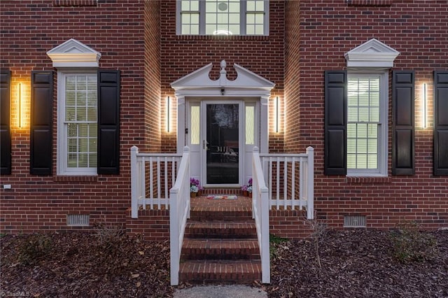 doorway to property featuring crawl space and brick siding