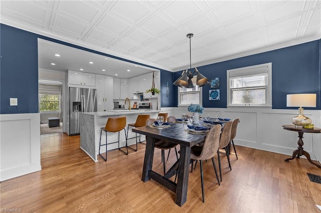 2607 Sherwood St, Greensboro, NC 27403 - dining area featuring light wood-style floors, wainscoting, an ornate ceiling, recessed lighting, and a decorative wall