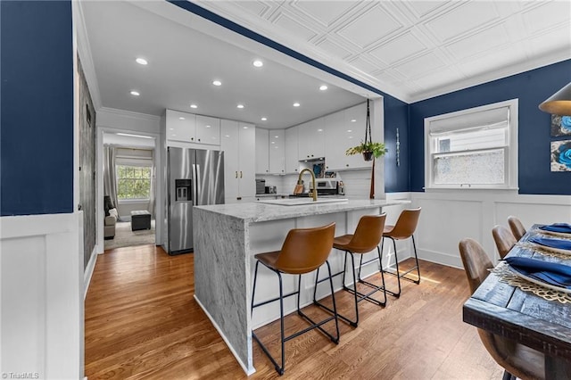 2607 Sherwood St, Greensboro, NC 27403 - kitchen featuring stainless steel refrigerator with ice dispenser, a peninsula, white cabinets, ornamental molding, and recessed lighting