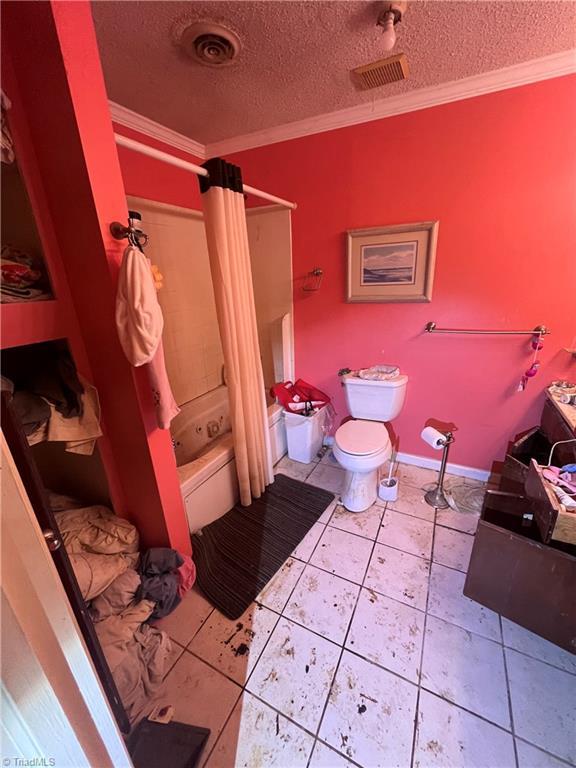 3603 Castleton Rd, Greensboro, NC 27406 - bathroom featuring crown molding, a textured ceiling, toilet, shower / bath combo with shower curtain, and tile patterned flooring