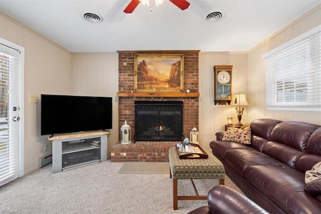 living room featuring crown molding, ceiling fan, light carpet, and a brick fireplace