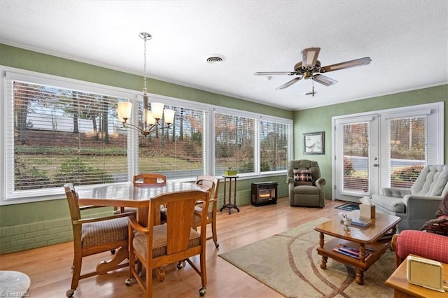 sunroom featuring ceiling fan with notable chandelier and french doors