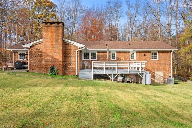 rear view of property with central air condition unit, a yard, and a deck