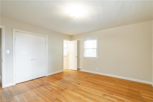 unfurnished bedroom with a closet and light hardwood / wood-style floors