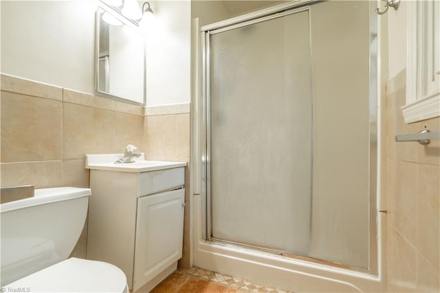 bathroom with tile walls, oversized vanity, an enclosed shower, toilet, and tile floors