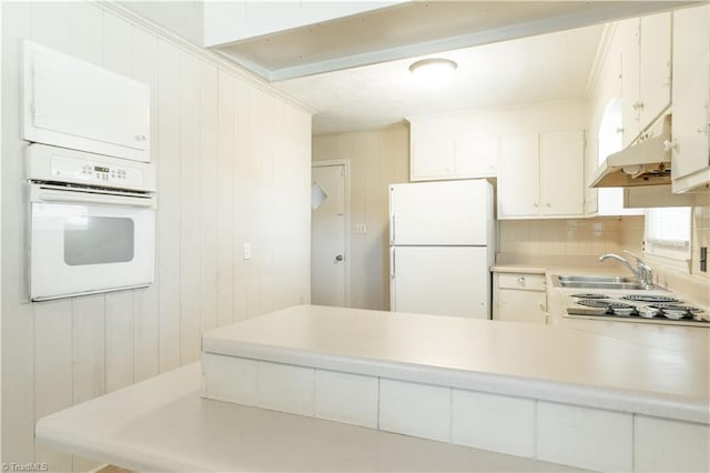 kitchen with white cabinets, sink, white appliances, tasteful backsplash, and crown molding