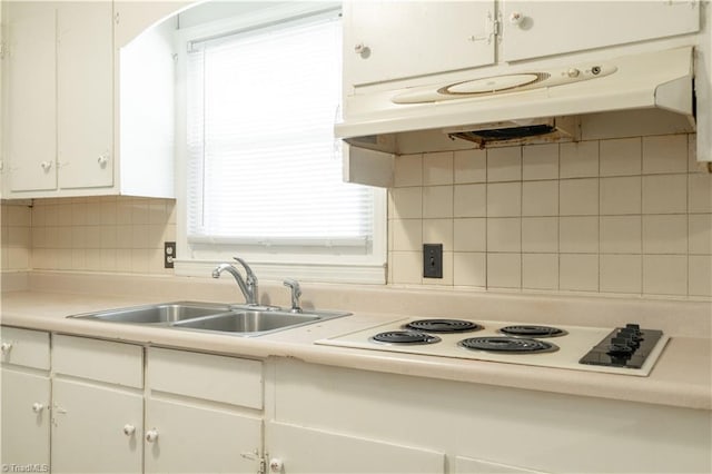 kitchen with white electric cooktop, tasteful backsplash, white cabinets, and sink