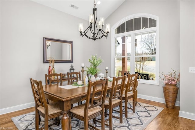 dining room featuring hardwood / wood-style floors and vaulted ceiling