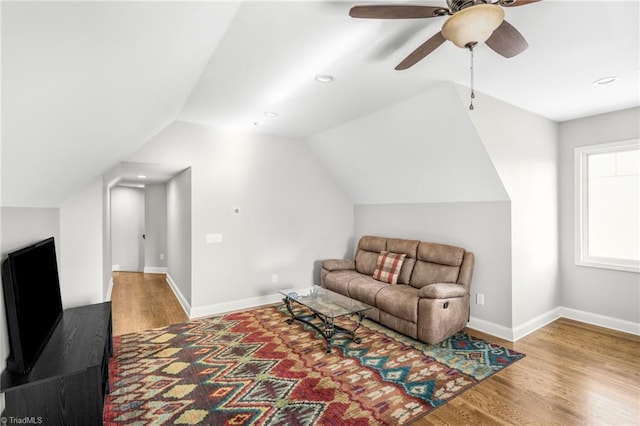 living room with lofted ceiling, ceiling fan, and light hardwood / wood-style flooring