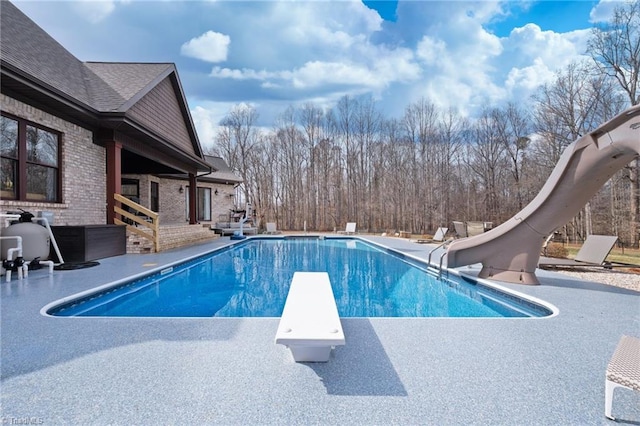 view of pool with a patio area, a diving board, and a water slide