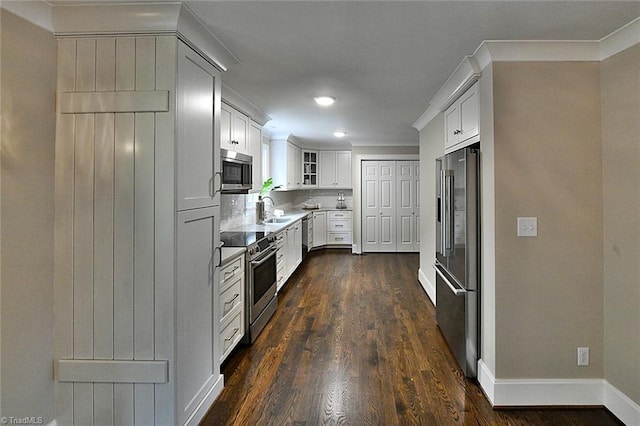 2700 Regency Dr, Winston-Salem, NC 27106 - kitchen featuring appliances with stainless steel finishes, a sink, dark wood-style floors, glass insert cabinets, and baseboards