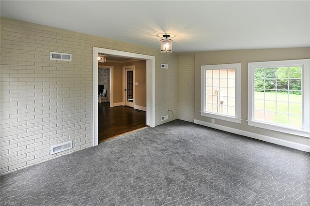 2700 Regency Dr, Winston-Salem, NC 27106 - unfurnished room featuring brick wall, dark carpet, and baseboards