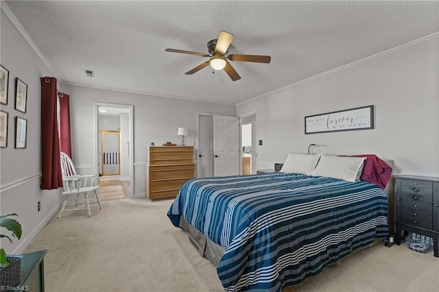 bedroom with a textured ceiling, light carpet, ceiling fan, connected bathroom, and ornamental molding