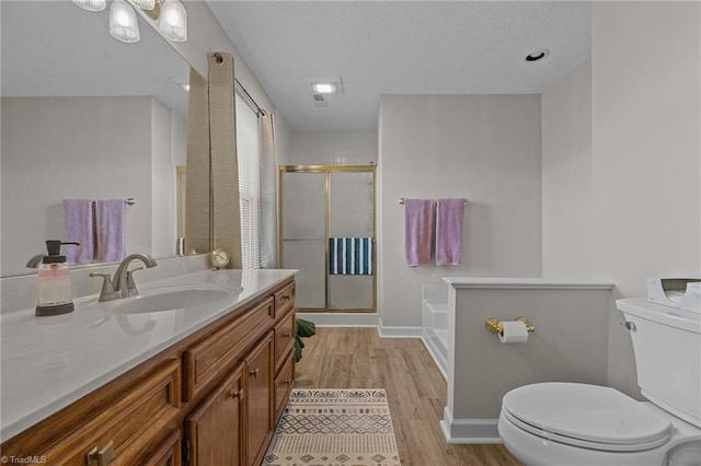 full bathroom with toilet, hardwood / wood-style flooring, shower with separate bathtub, and vanity