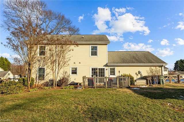 rear view of house featuring a yard and a wooden deck