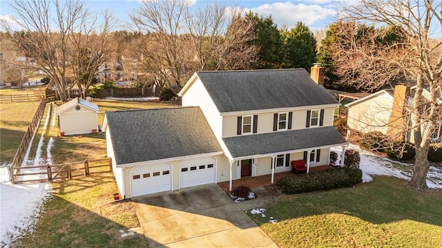 view of front of home with a garage, a storage shed, and a front lawn