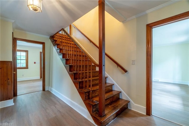 staircase with hardwood / wood-style flooring and crown molding