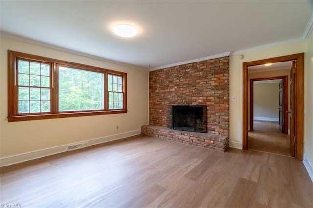 unfurnished living room with ornamental molding, a fireplace, and light hardwood / wood-style flooring