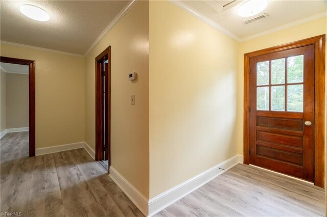 doorway to outside featuring ornamental molding, light hardwood / wood-style floors, and a textured ceiling