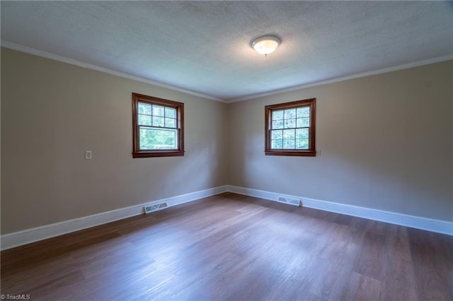 unfurnished room with a textured ceiling, crown molding, and dark wood-type flooring