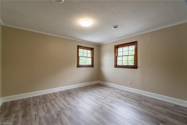 empty room with crown molding, wood-type flooring, and a textured ceiling