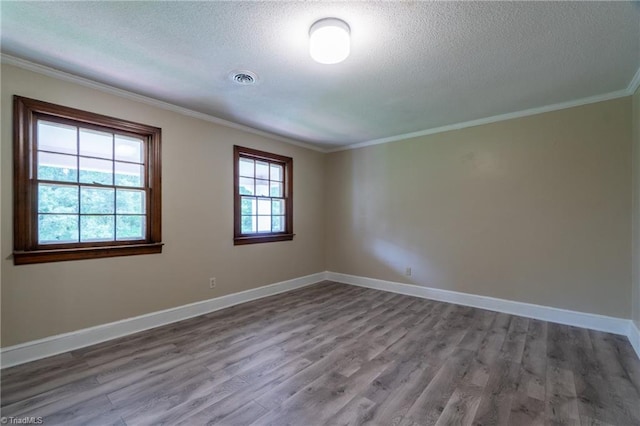 spare room with ornamental molding, wood-type flooring, and a textured ceiling